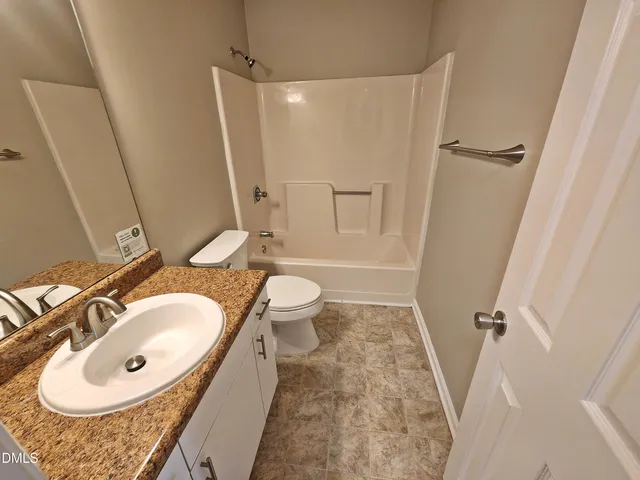 a bathroom with a sink toilet a mirror and shower