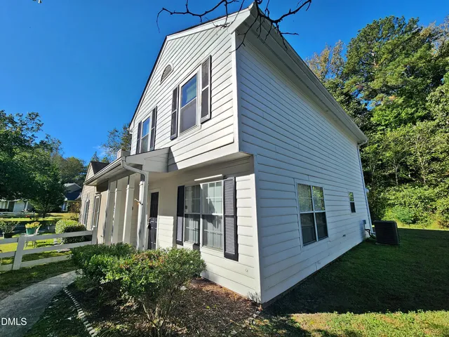a view of a white house with a yard