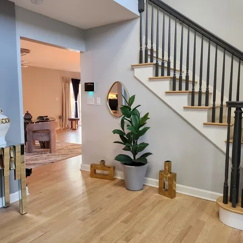 a view of entryway and hall with wooden floor