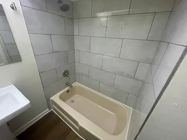 a bathroom with a white bath tub and shower