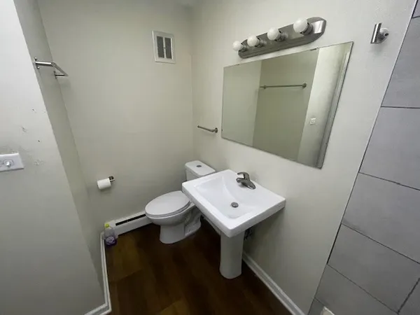 a bathroom with a sink a toilet and mirror