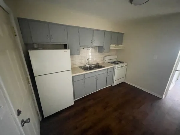 a kitchen with a sink a refrigerator and cabinets