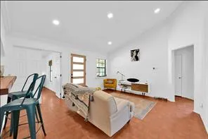 a living room with furniture a flat screen tv and a window