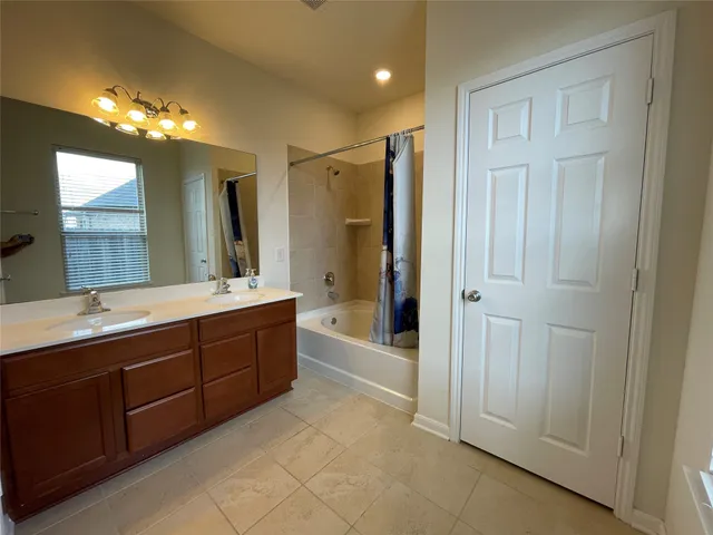 a spacious bathroom with a shower a sink and a large mirror