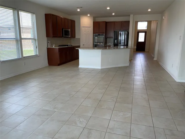 a view of a living room with kitchen appliances