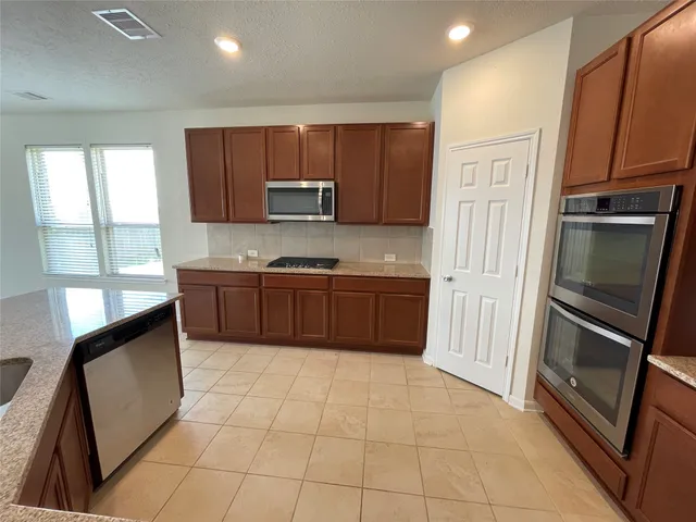 a kitchen with stainless steel appliances granite countertop a refrigerator sink and microwave