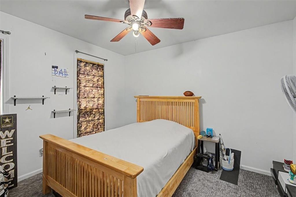 409 Windsor Way Canton, GA 30115 - Photo 22 of 51 a bedroom with a bed and a chandelier