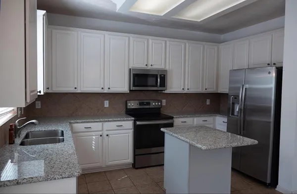 a kitchen with a sink and a stove top oven