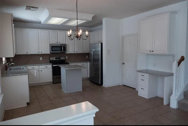 a kitchen with a sink a counter top space cabinets and stainless steel appliances