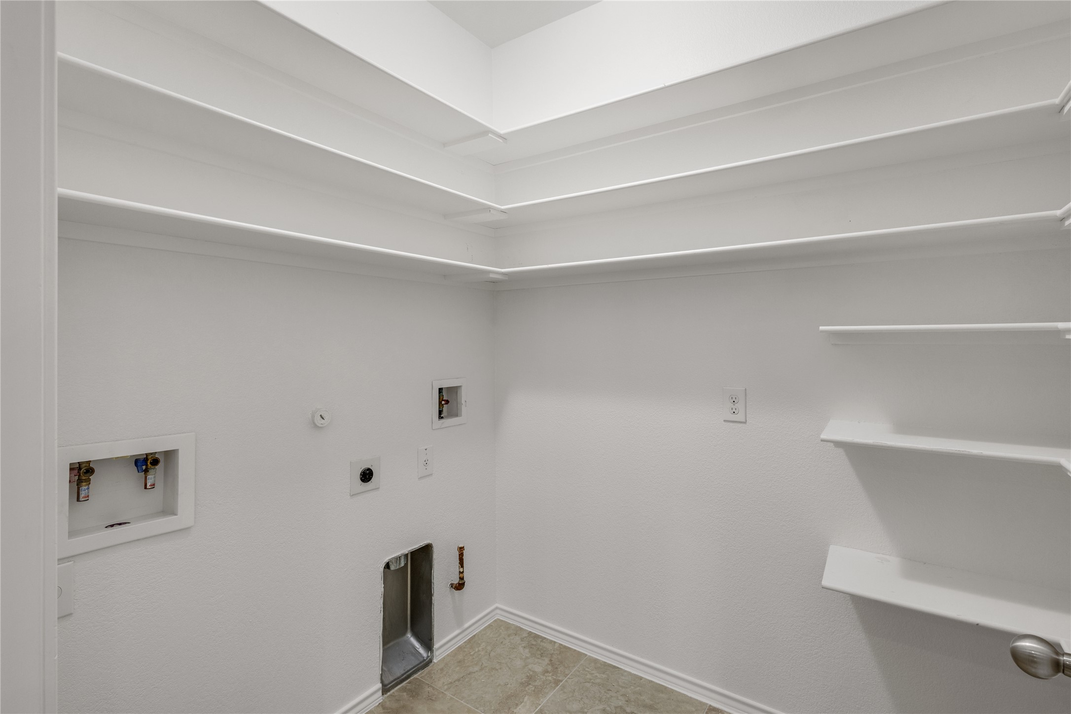 397 Limerick Road Buda, TX 78610 - Photo 11 of 33 Off the kitchen is a massive utility room that doubles as a dream pantry. With floor-to-ceiling built-in shelving, there is enough storage for all your bulk groceries, linens, and laundry essentials.