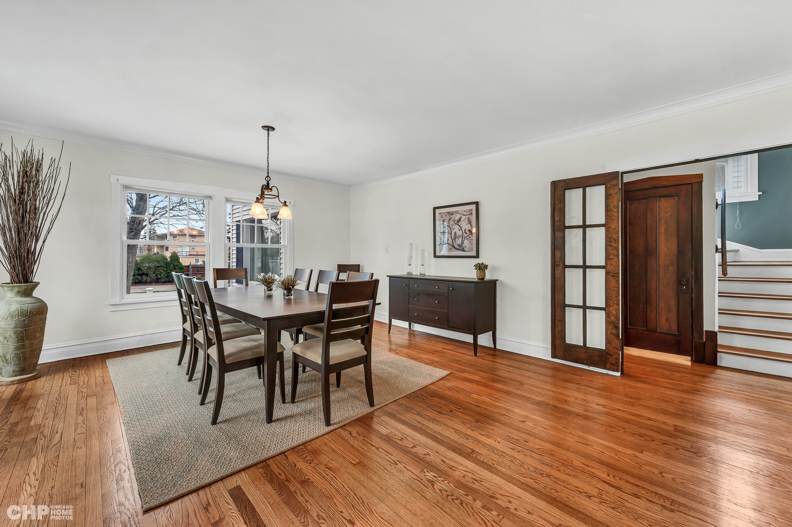 304 Maplewood Road Riverside, IL 60546 - Photo 8 of 38 a dining room with wooden floor a chandelier a wooden table and chairs