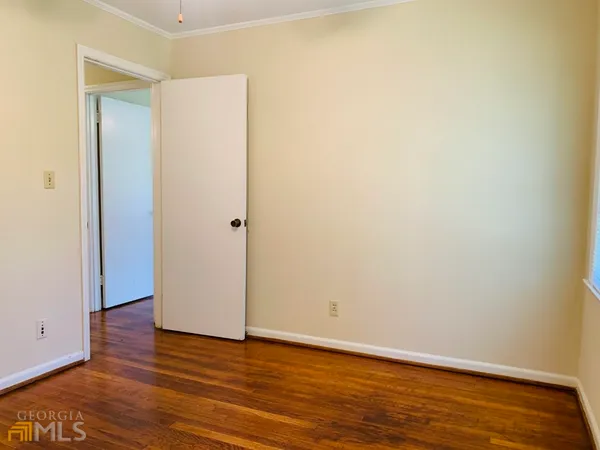a view of an empty room with wooden floor