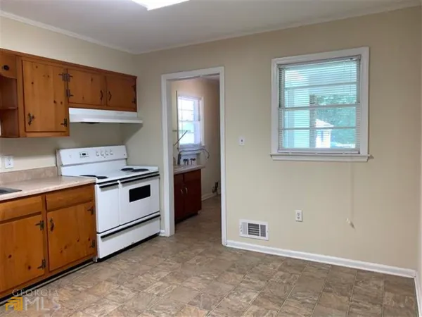 a kitchen with granite countertop white cabinets and white appliances