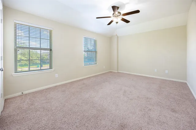 an empty room with a window and a fan