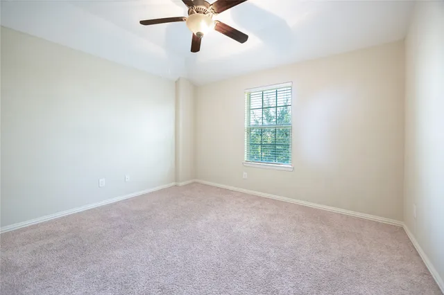 an empty room with a window and a fan