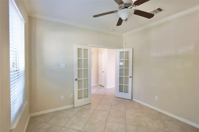 a view of an empty room with a window and a ceiling fan