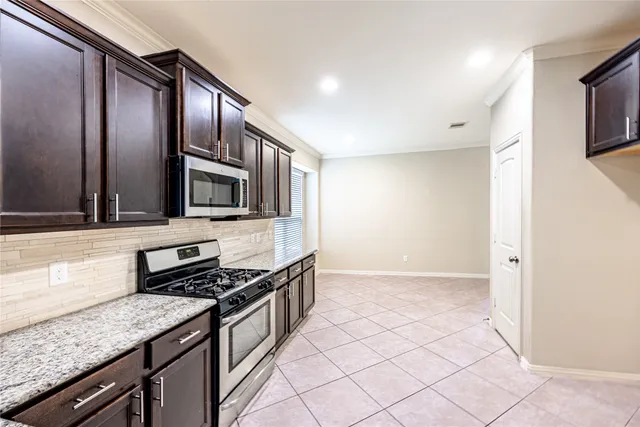 a kitchen with stainless steel appliances granite countertop a stove and a microwave