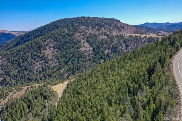 a view of a dry yard with mountains in the background