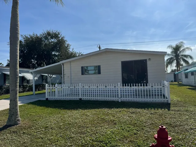 a view of a house with a wooden deck and a yard