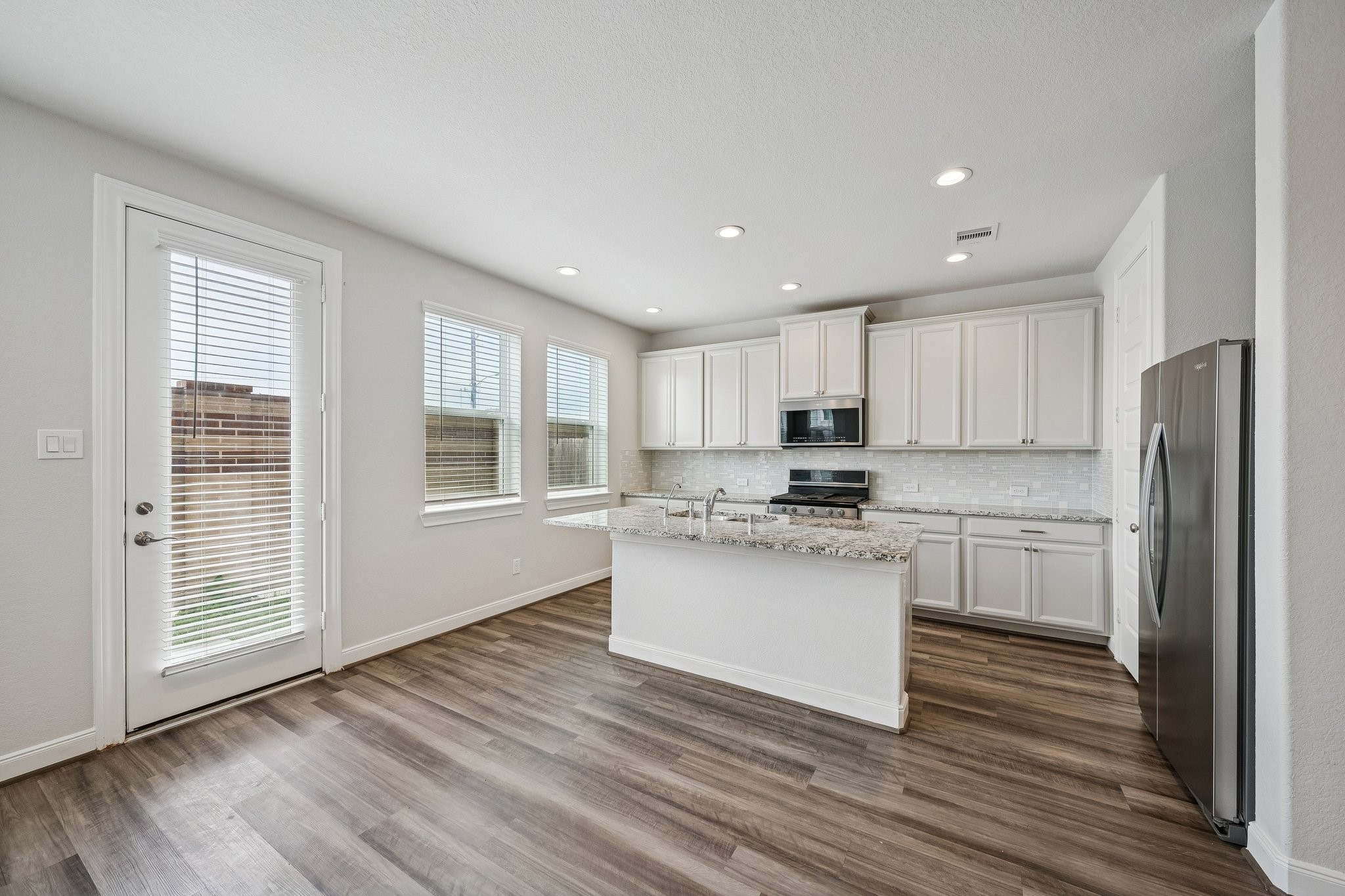 9817 Prairie Garden Lane Houston, TX 77080 - Photo 8 of 36 a kitchen with a refrigerator wooden floor and a window