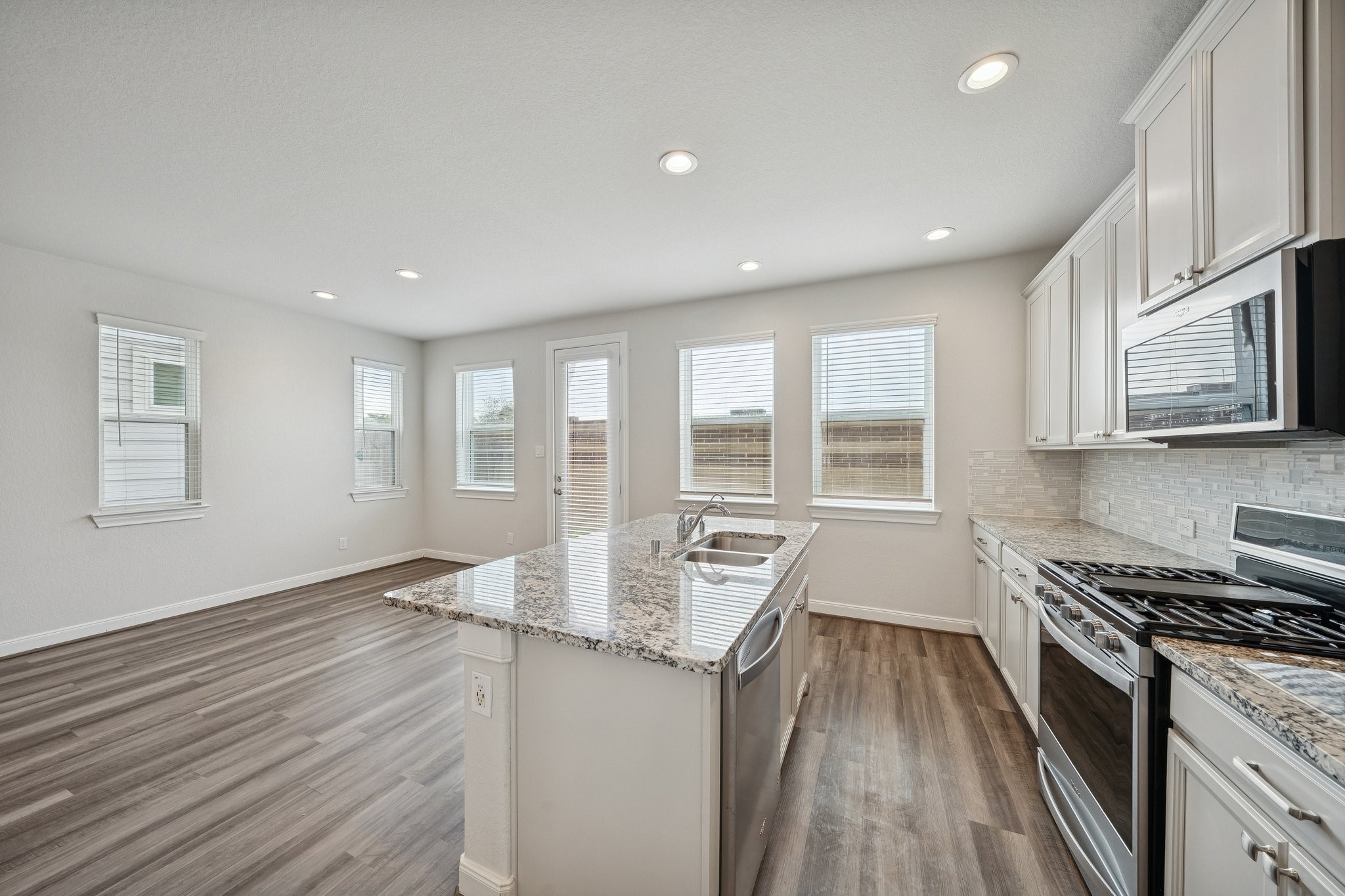 9817 Prairie Garden Lane Houston, TX 77080 - Photo 9 of 36 a large kitchen with stainless steel appliances a large counter top a stove a sink and a refrigerator