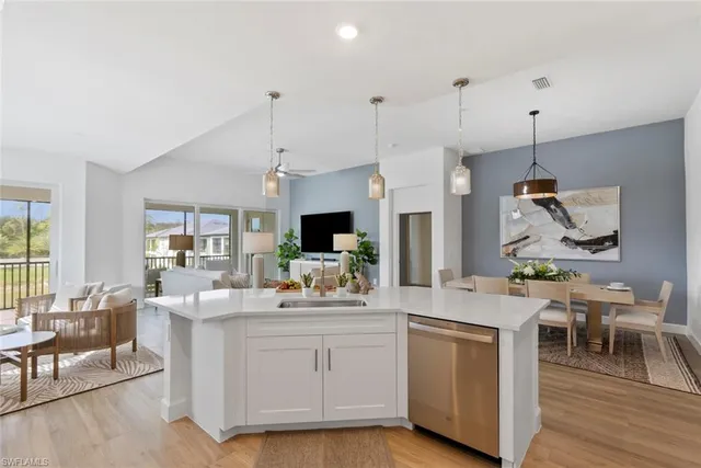 a room with kitchen island a sink and a flat screen tv