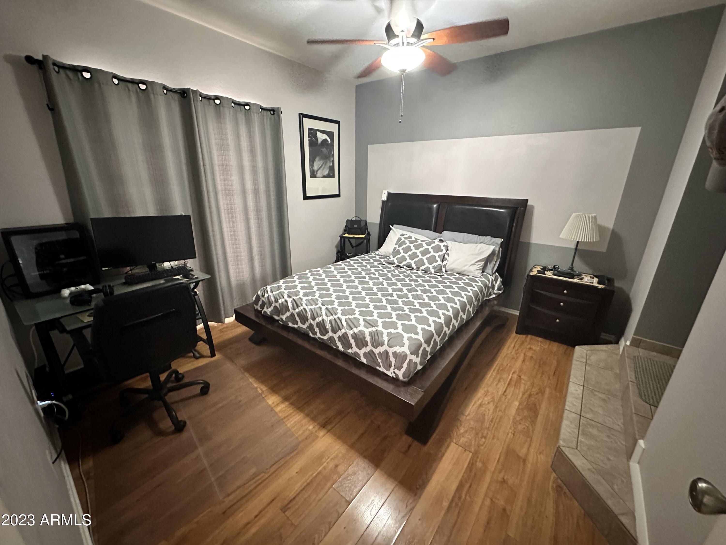 154 West 5th Street, Unit 149 Tempe, AZ 85281 - Photo 4 of 9 a bedroom with a bed wooden floor and a flat tv screen