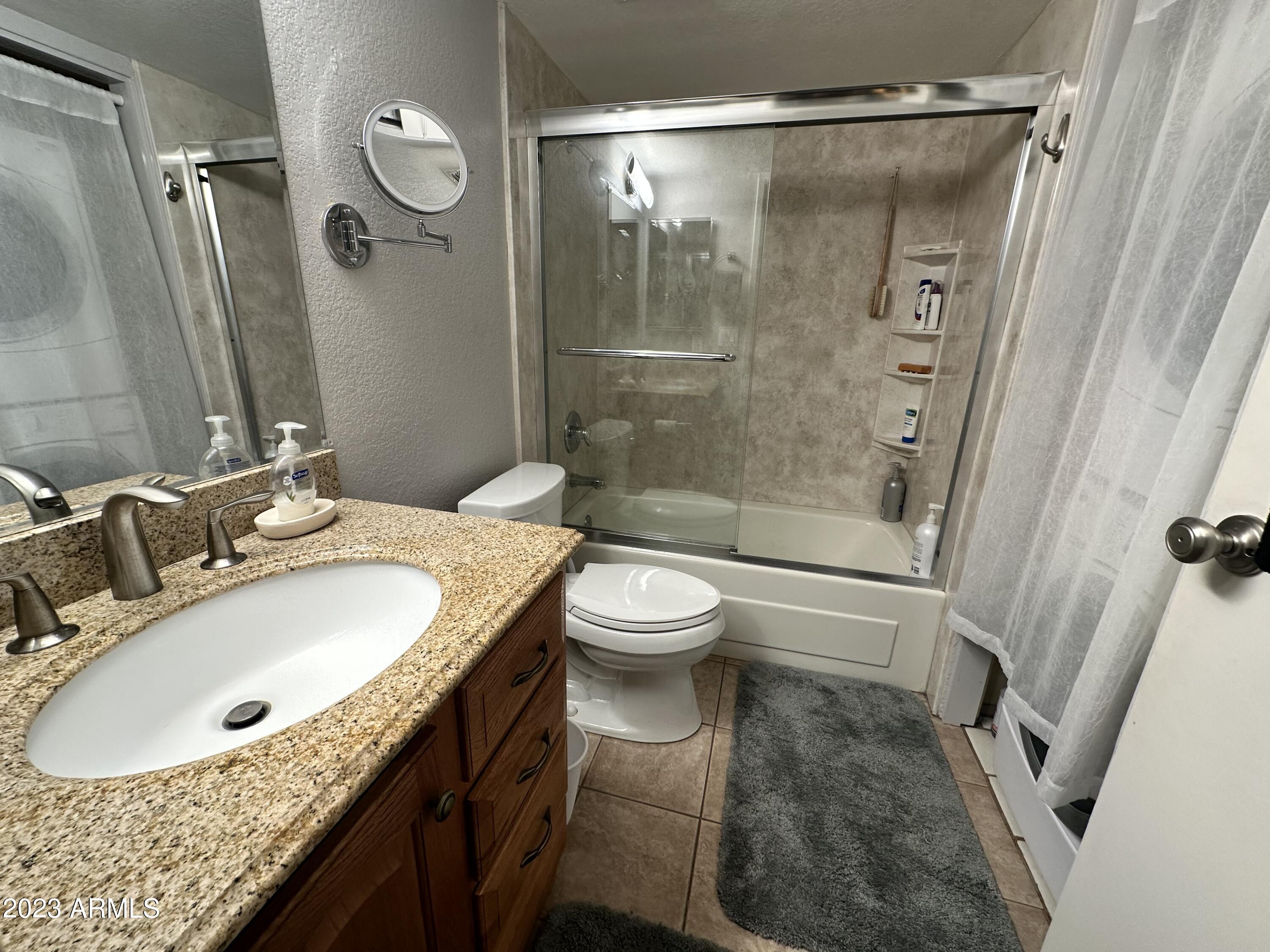 154 West 5th Street, Unit 149 Tempe, AZ 85281 - Photo 6 of 9 a bathroom with a granite countertop sink toilet and shower