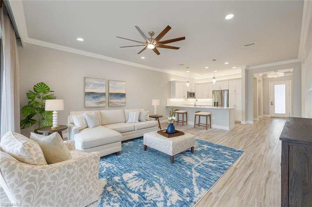 Living room featuring ornamental molding, ceiling fan, recessed lighting, and wood finish floors