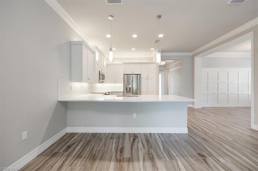 13418 Silktail Drive Naples, FL 34109 - Photo 11 of 36 a view of kitchen with wooden floor and window