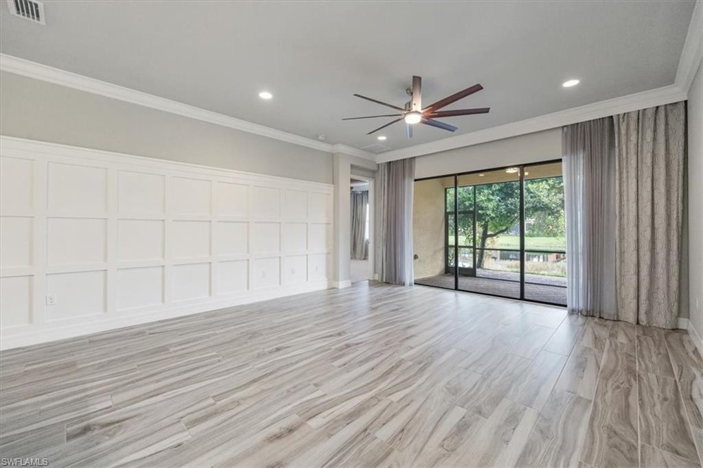 13418 Silktail Drive Naples, FL 34109 - Photo 14 of 36 wooden floor in an empty room with a window