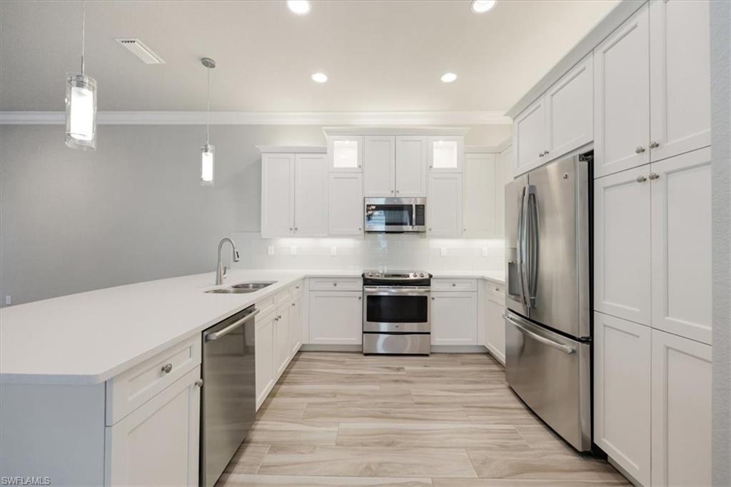 13418 Silktail Drive Naples, FL 34109 - Photo 17 of 36 a kitchen with stainless steel appliances a refrigerator sink and microwave