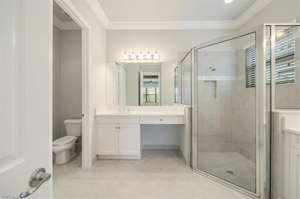 13418 Silktail Drive Naples, FL 34109 - Photo 24 of 36 a bathroom with a double vanity sink toilet and shower