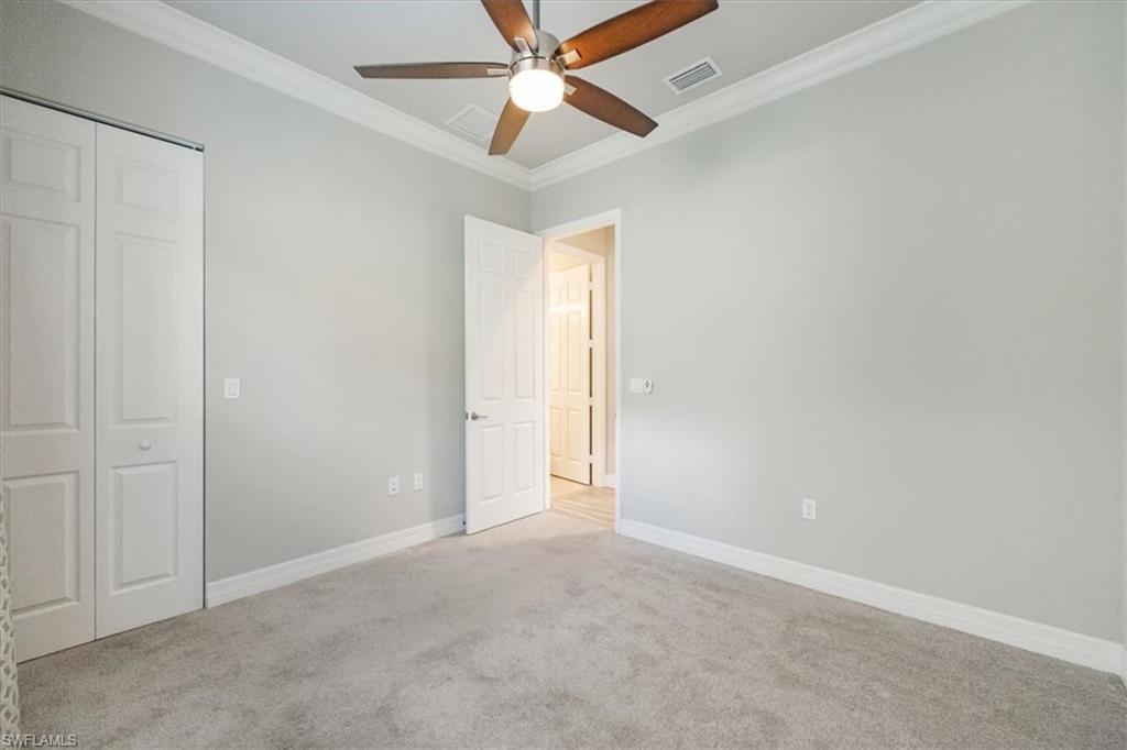 13418 Silktail Drive Naples, FL 34109 - Photo 26 of 36 an empty room with closet and a ceiling fan