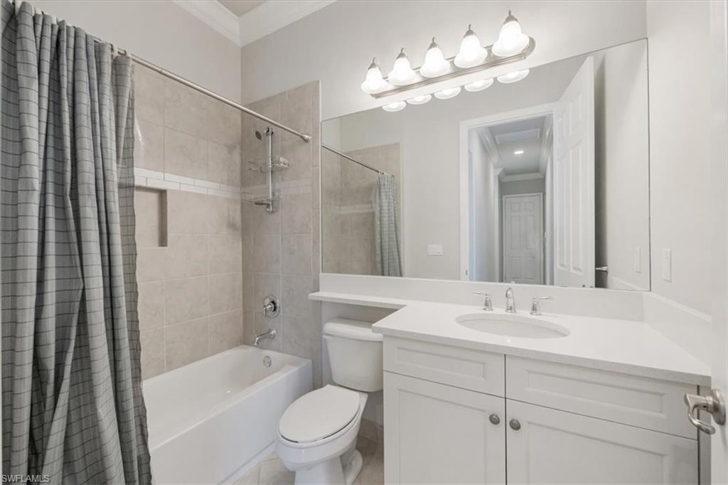 13418 Silktail Drive Naples, FL 34109 - Photo 27 of 36 a bathroom with a toilet a sink a mirror a bathtub and shower