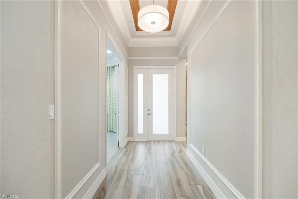 13418 Silktail Drive Naples, FL 34109 - Photo 10 of 36 a view of a hallway with wooden floor
