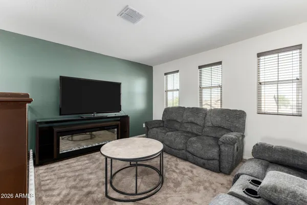 a living room with furniture a flat screen tv and a window