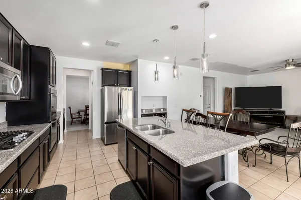 a kitchen with stainless steel appliances granite countertop a stove top oven a refrigerator a sink and a stove