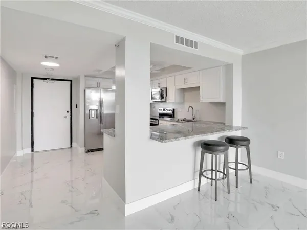 a kitchen with stainless steel appliances kitchen island granite countertop a refrigerator and a sink