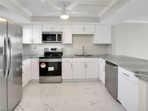 a kitchen with stainless steel appliances granite countertop a stove a sink and a refrigerator