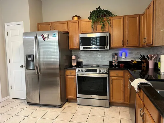 a kitchen with stainless steel appliances granite countertop a refrigerator microwave and sink