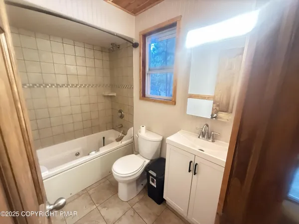 a bathroom with a toilet a sink a mirror a bathtub and shower