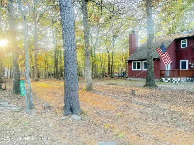 a view of a house with backyard and trees