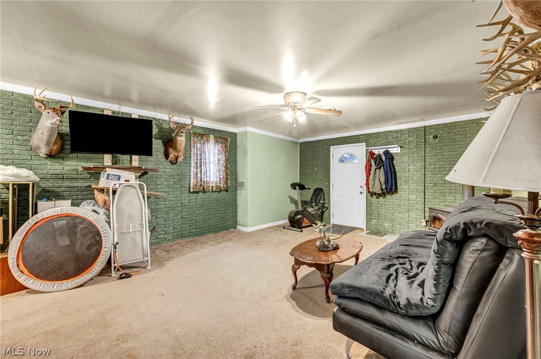 3830 Jerusalem Road Vermilion, OH 44089 - Photo 14 of 49 Living area with carpet flooring, crown molding, brick wall, and ceiling fan
