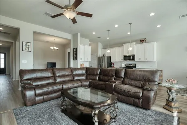 a living room with furniture and a view of kitchen