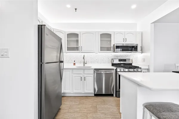 a kitchen with stainless steel appliances granite countertop a refrigerator sink and stove