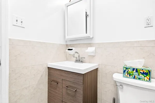 a bathroom with a sink vanity mirror and toilet