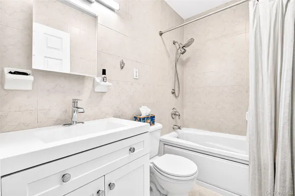 a bathroom with a sink a mirror toilet and bathtub