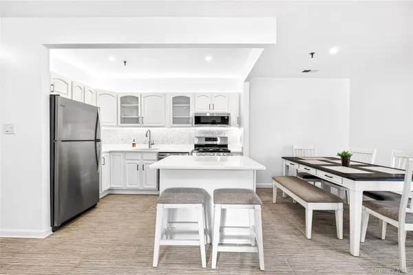 a kitchen with stainless steel appliances granite countertop a stove a refrigerator and a dining table