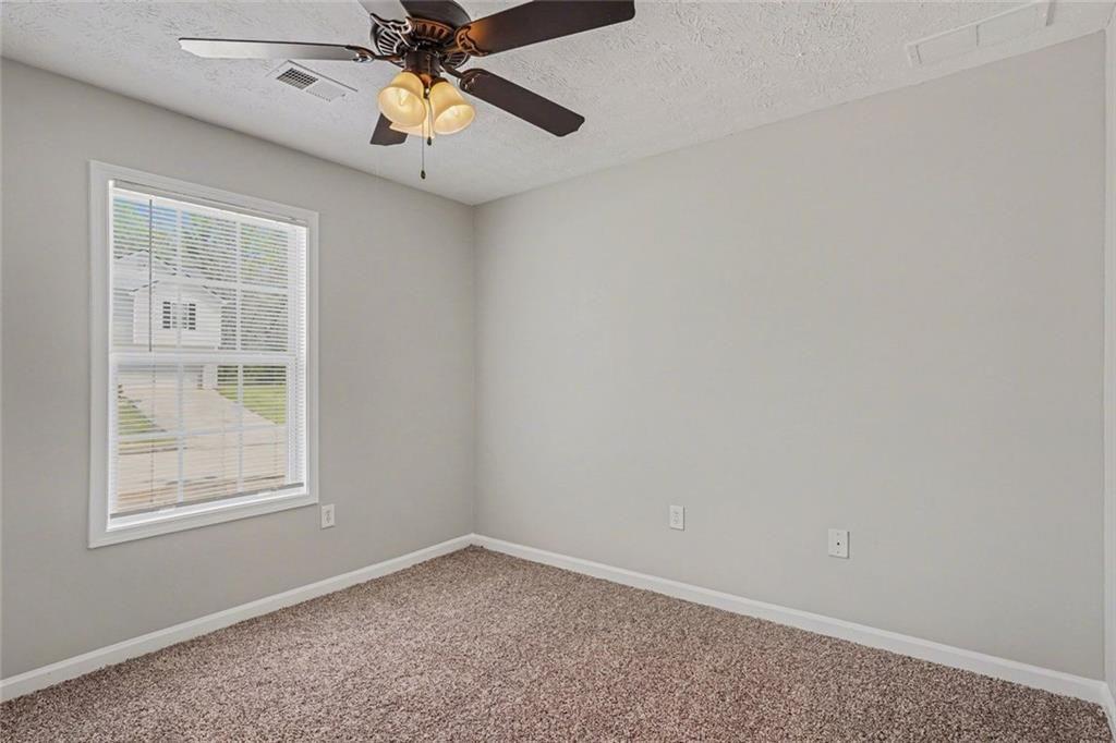 10 Wilbur Way Covington, GA 30016 - Photo 11 of 22 an empty room with a window and a fan